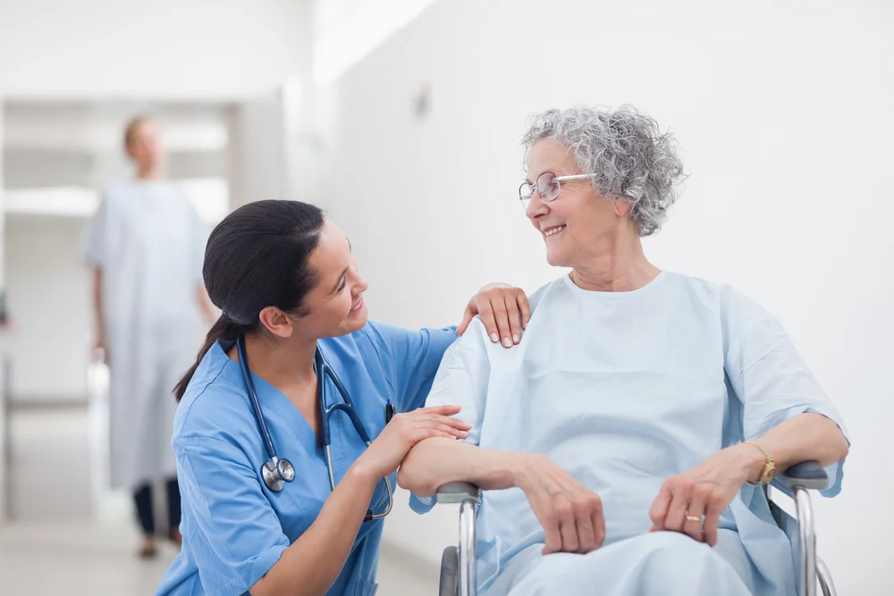 Elderly Patient Looking At A Nurse In Hospital Ward